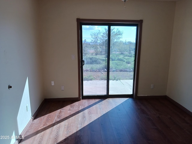 unfurnished room featuring baseboards and wood finished floors