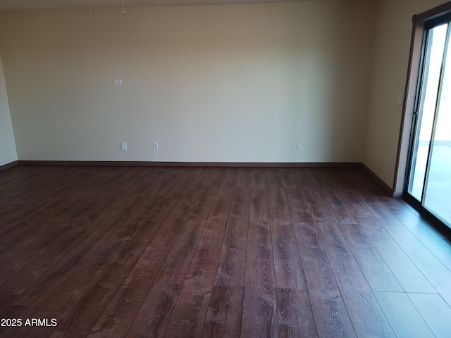 unfurnished room with dark wood-style flooring, baseboards, and plenty of natural light
