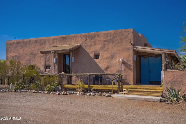 pueblo-style home with fence