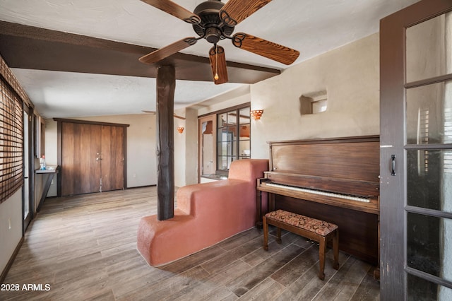 sitting room with a ceiling fan and wood finished floors