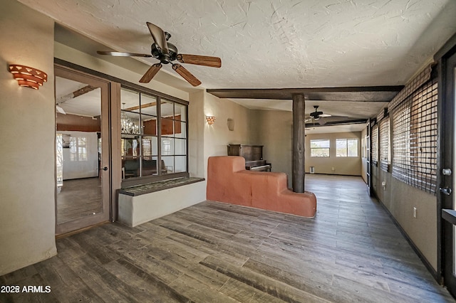 unfurnished living room featuring a textured ceiling, ceiling fan, and wood finished floors