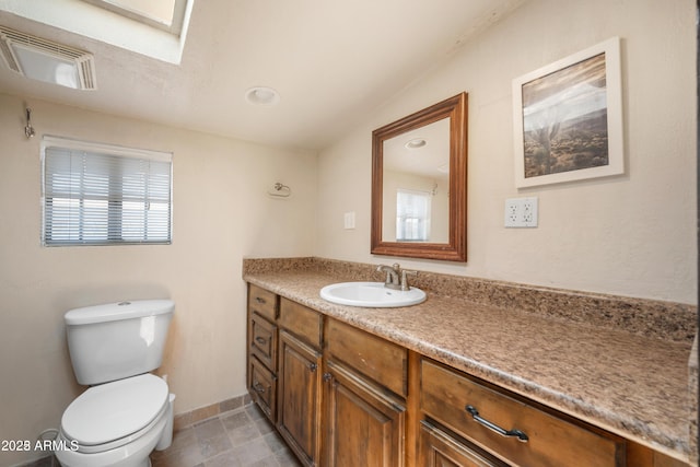bathroom with visible vents, toilet, vanity, and baseboards
