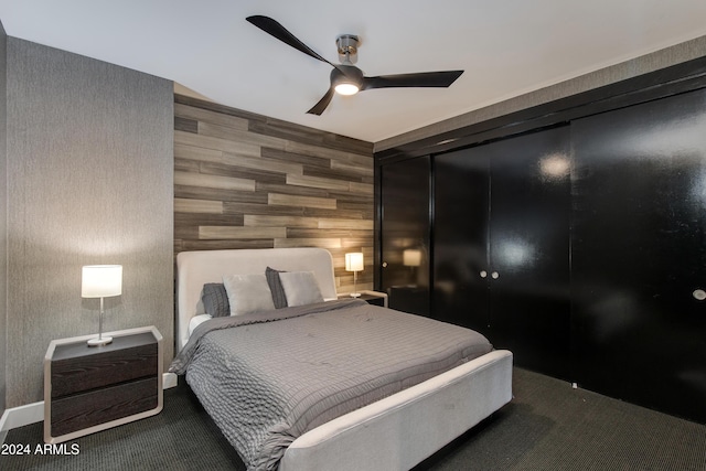 bedroom featuring ceiling fan and wood walls