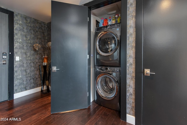 laundry room featuring dark hardwood / wood-style flooring and stacked washer / drying machine