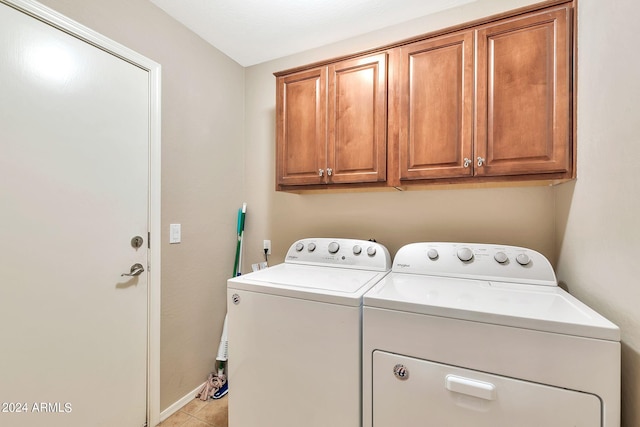 washroom with washer and clothes dryer, cabinets, and light tile patterned flooring