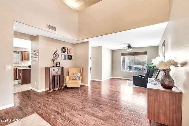 living area with wood-type flooring and ceiling fan