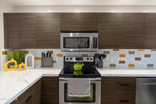 19700 N 76th St Unit 1038, Scottsdale, AZ 85255 - kitchen with stainless steel appliances, tasteful backsplash, dark brown cabinetry, and modern cabinets