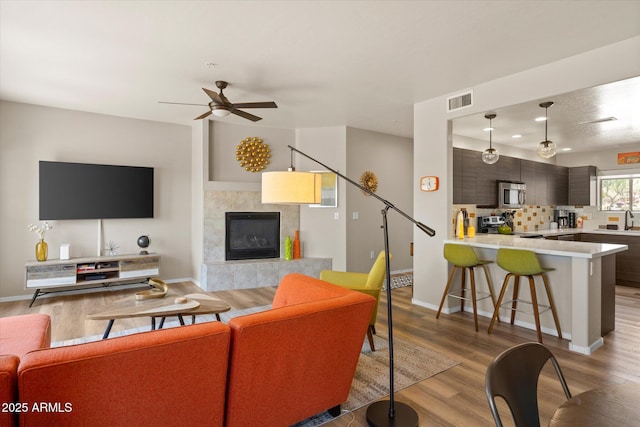 19700 N 76th St Unit 1038, Scottsdale, AZ 85255 - living area with light wood-style floors, ceiling fan, and a fireplace