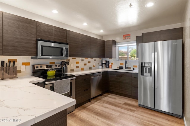 19700 N 76th St Unit 1038, Scottsdale, AZ 85255 - kitchen with appliances with stainless steel finishes, dark brown cabinets, backsplash, light stone counters, and recessed lighting