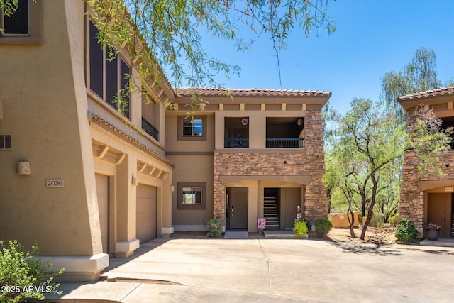 19700 N 76th St Unit 1038, Scottsdale, AZ 85255 - view of front facade with concrete driveway, stucco siding, a balcony, stone siding, and a garage