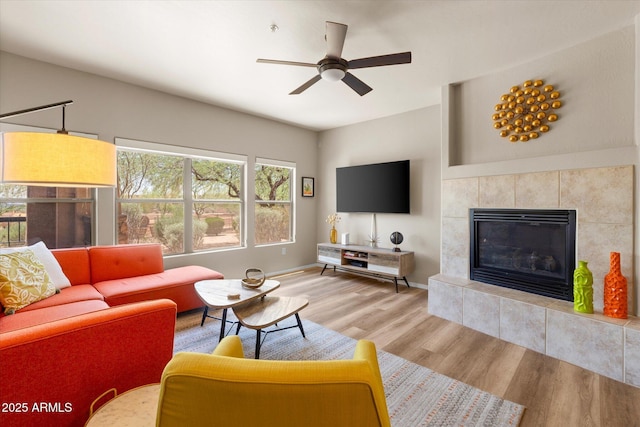 19700 N 76th St Unit 1038, Scottsdale, AZ 85255 - living area with wood finished floors, a ceiling fan, and a tiled fireplace
