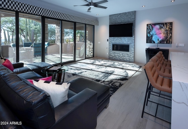 living room featuring a fireplace, wood-type flooring, and ceiling fan