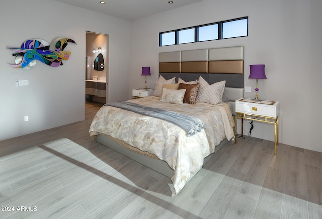 bedroom featuring ensuite bathroom and light hardwood / wood-style floors