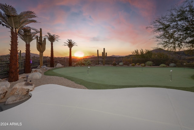 surrounding community with a mountain view and a patio