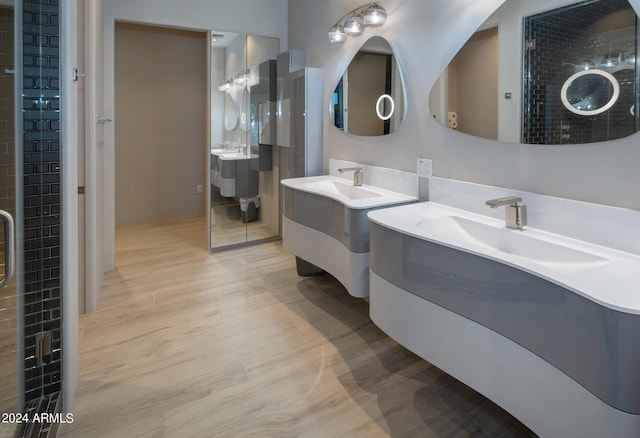 bathroom with vanity, wood-type flooring, and tiled shower