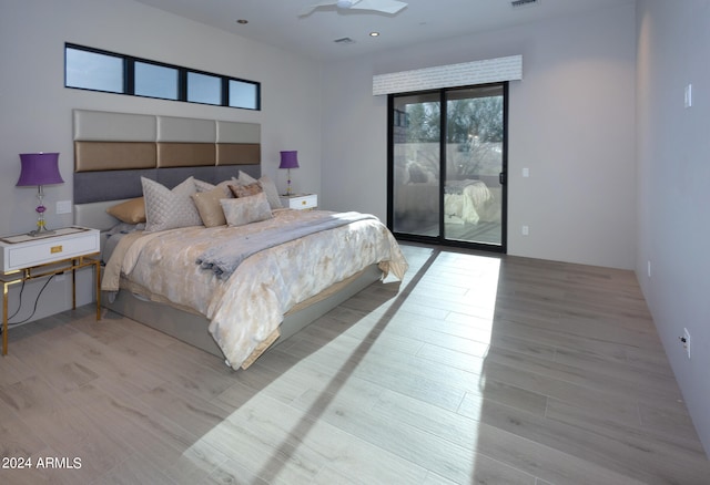 bedroom featuring access to exterior and light wood-type flooring