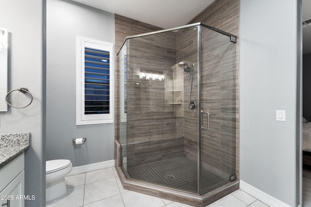 bathroom with vanity, toilet, a shower with shower door, and tile patterned flooring