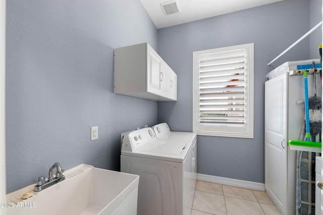 clothes washing area featuring cabinets, washing machine and clothes dryer, sink, and light tile patterned floors