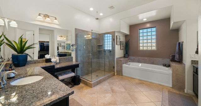 bathroom featuring plus walk in shower, tile patterned floors, and vanity