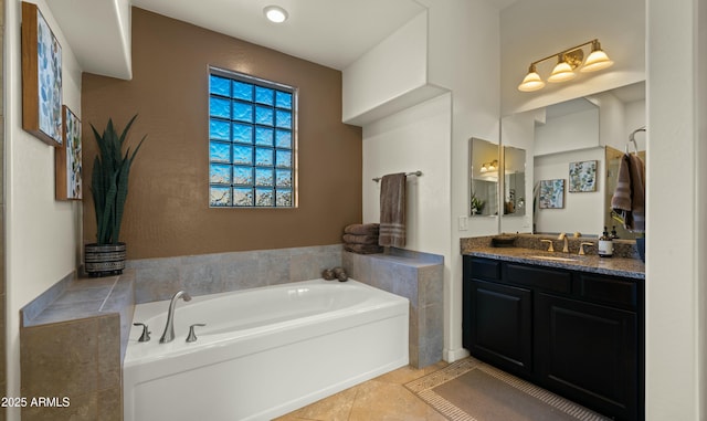 bathroom with tile patterned flooring, a bathtub, and vanity