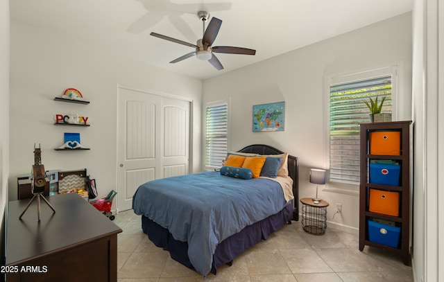 tiled bedroom with a closet, multiple windows, and ceiling fan