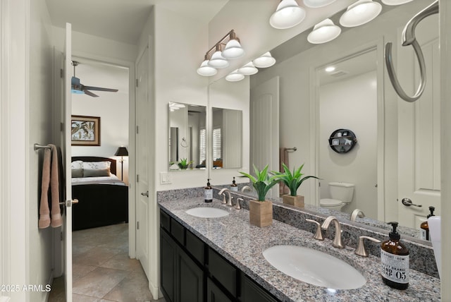 bathroom featuring toilet, ceiling fan, and vanity