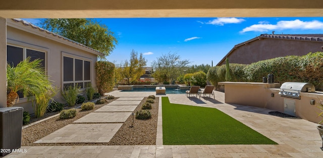 view of yard featuring a patio area, an outdoor kitchen, and central AC