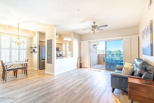 living room featuring light hardwood / wood-style flooring and ceiling fan