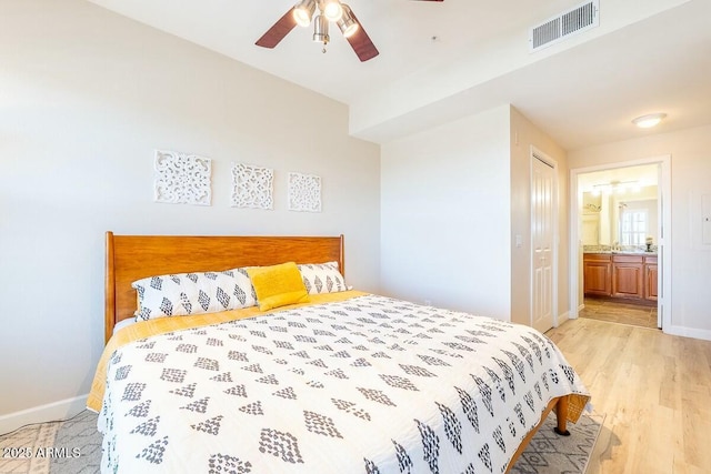 bedroom with a closet, ceiling fan, light hardwood / wood-style flooring, and ensuite bathroom