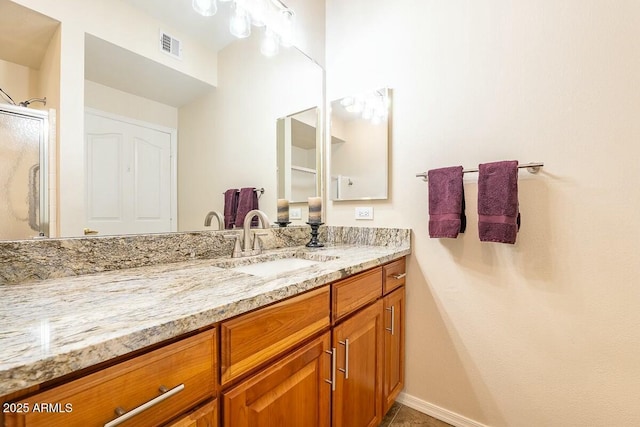 bathroom featuring vanity and a shower with door