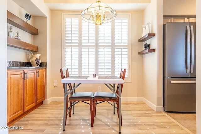 dining space featuring light hardwood / wood-style flooring and a chandelier