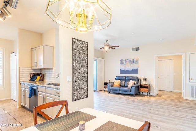 dining room with sink, ceiling fan with notable chandelier, and light hardwood / wood-style flooring