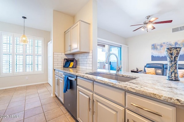 kitchen featuring dishwasher, sink, tasteful backsplash, light tile patterned flooring, and light stone counters