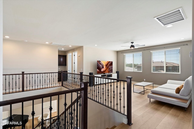 hall featuring light wood-style flooring, recessed lighting, an upstairs landing, and visible vents