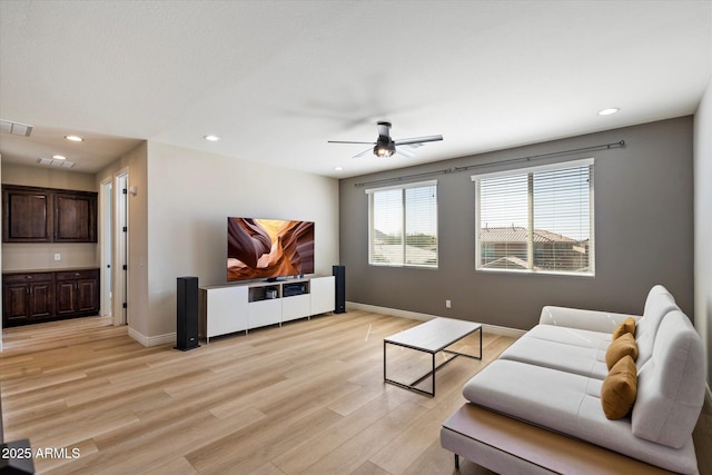 living area featuring a ceiling fan, recessed lighting, baseboards, and light wood finished floors