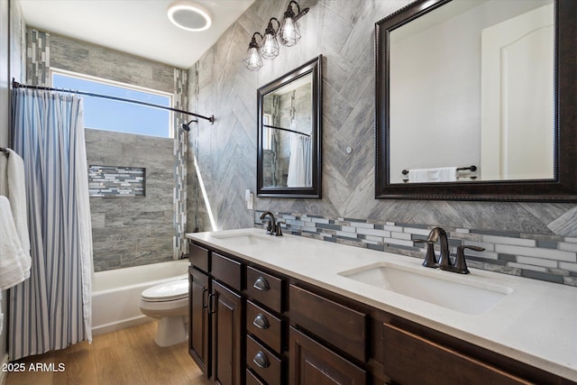 bathroom with a sink, shower / bathtub combination with curtain, tasteful backsplash, and toilet