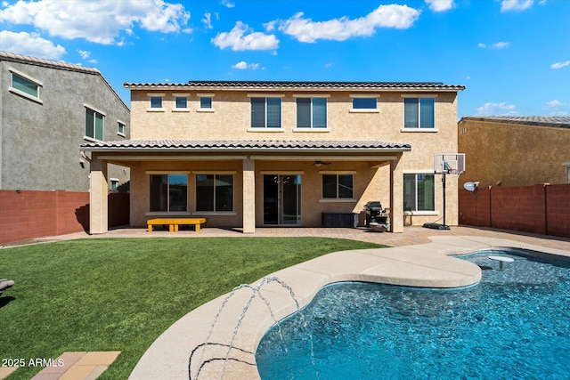 rear view of house featuring a patio, a yard, a fenced backyard, and stucco siding