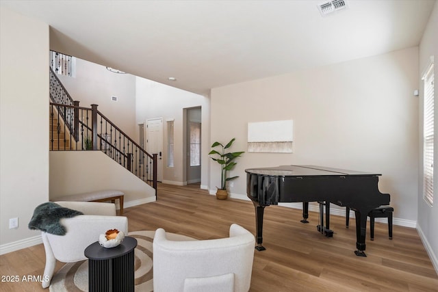 sitting room with visible vents, baseboards, wood finished floors, and stairs