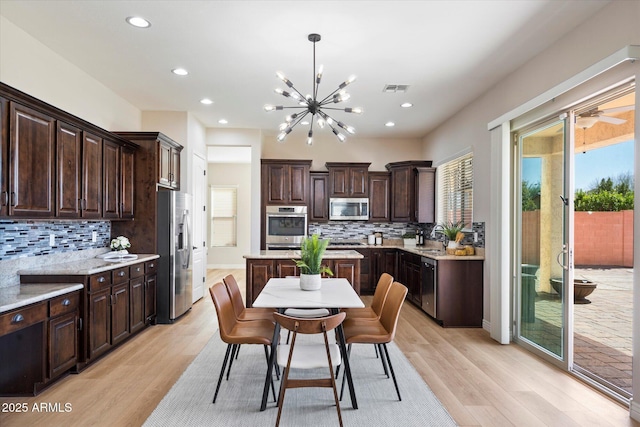 kitchen with visible vents, a sink, dark brown cabinetry, appliances with stainless steel finishes, and light wood finished floors