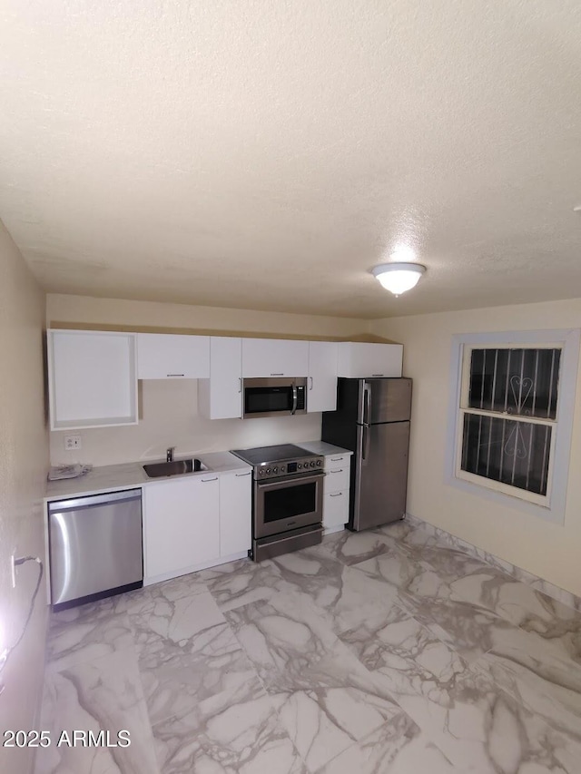 126 N 9th Ave, Phoenix, AZ 85007 - kitchen featuring appliances with stainless steel finishes, white cabinetry, a textured ceiling, light marble finish floors, and light countertops