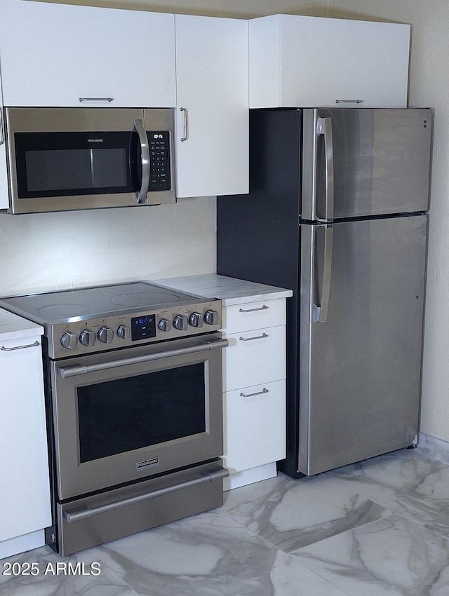 126 N 9th Ave, Phoenix, AZ 85007 - kitchen with appliances with stainless steel finishes, white cabinetry, light marble finish floors, and light countertops