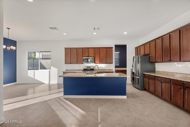 kitchen featuring light stone countertops, light tile patterned floors, decorative light fixtures, stainless steel appliances, and a chandelier