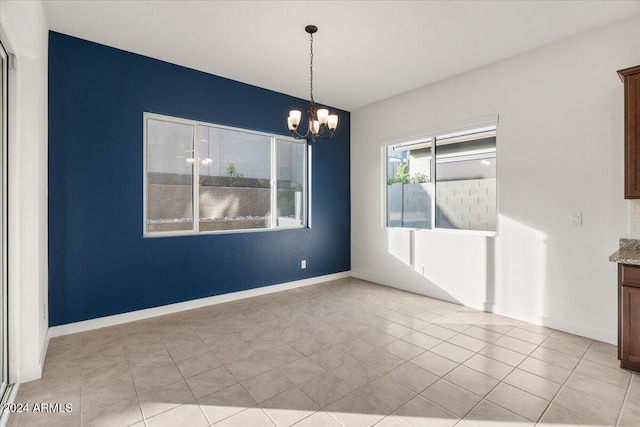 unfurnished dining area with light tile patterned floors and a chandelier