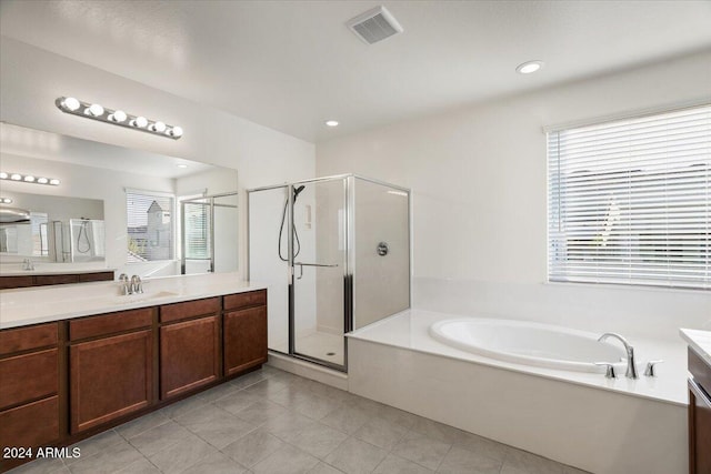 bathroom with vanity, a healthy amount of sunlight, and separate shower and tub