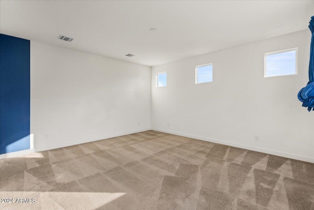 empty room with light colored carpet and plenty of natural light