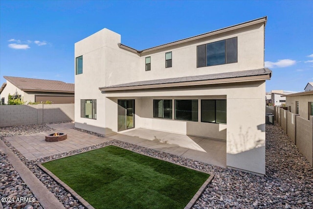 back of house with an outdoor fire pit and a patio area