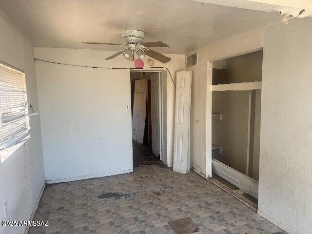 interior space with ceiling fan and visible vents