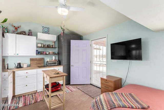 bedroom with a toaster, light colored carpet, ceiling fan, vaulted ceiling, and an AC wall unit