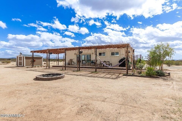 rear view of property featuring a storage unit and an outbuilding