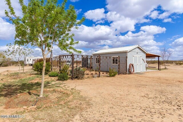 view of yard featuring dirt driveway and an outbuilding